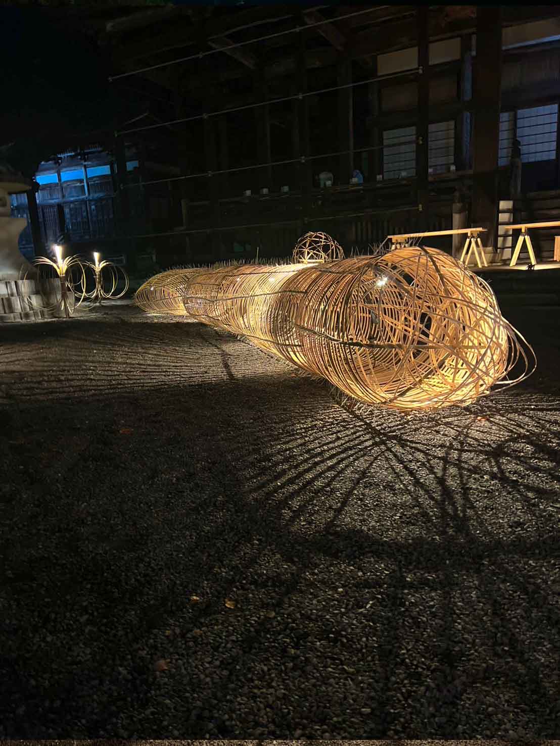 竹之助による『たけ花あかり』の作品。灯籠の光と花が調和した幻想的な夜の境内。